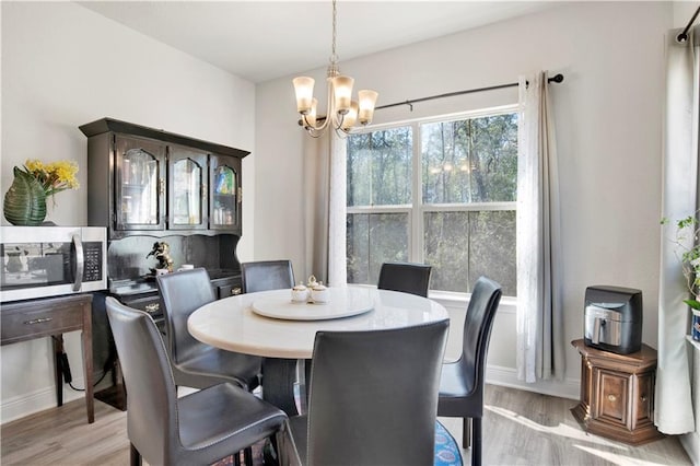 dining area featuring light hardwood / wood-style flooring and a chandelier