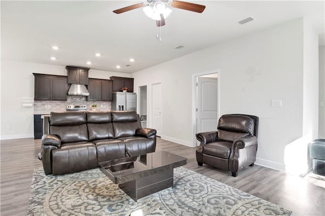 living room with ceiling fan and light wood-type flooring