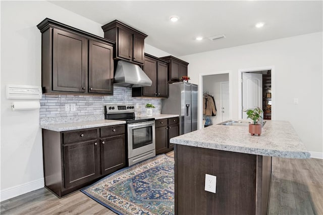 kitchen with sink, extractor fan, dark brown cabinets, appliances with stainless steel finishes, and light hardwood / wood-style floors