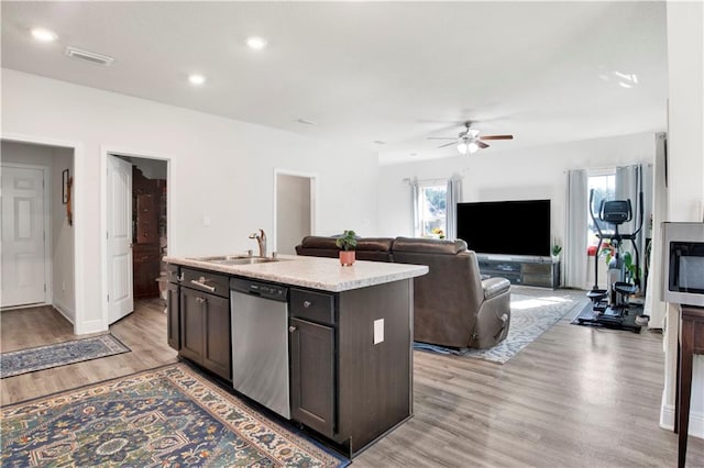 kitchen featuring sink, dishwasher, a kitchen island with sink, dark brown cabinetry, and light hardwood / wood-style floors