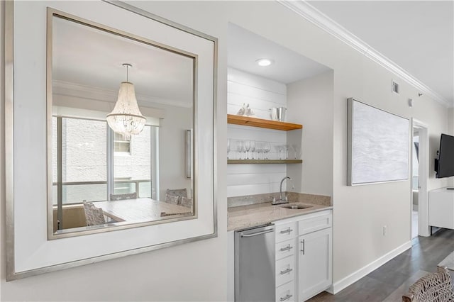 bar with a sink, wet bar, baseboards, crown molding, and dark wood-type flooring