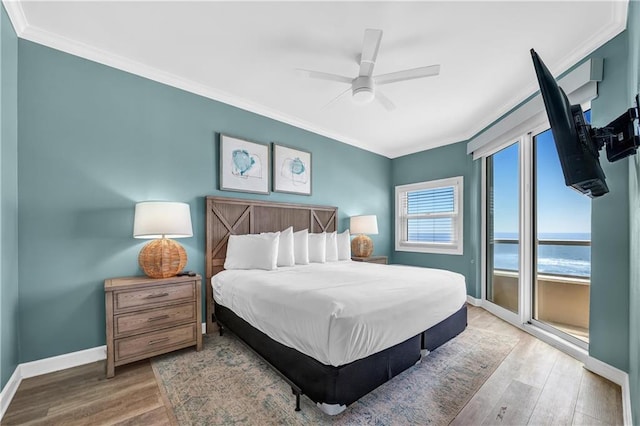 bedroom featuring wood finished floors, crown molding, and baseboards