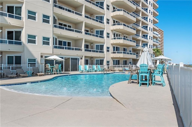 pool with a patio and fence