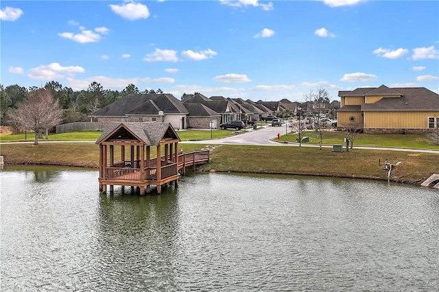 dock area with a residential view, a water view, a yard, and a gazebo