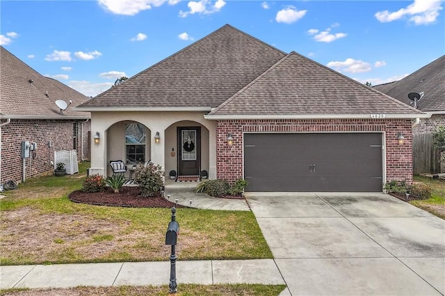 view of front of property with a garage, driveway, roof with shingles, and covered porch