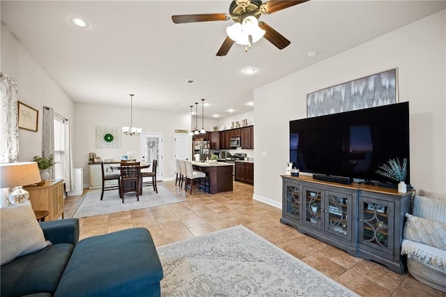 living area featuring light tile patterned floors, recessed lighting, visible vents, baseboards, and ceiling fan with notable chandelier