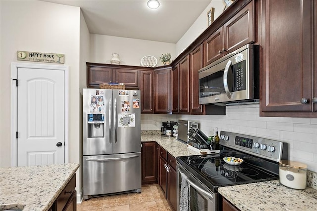 kitchen featuring dark brown cabinetry, light stone counters, stainless steel appliances, and decorative backsplash