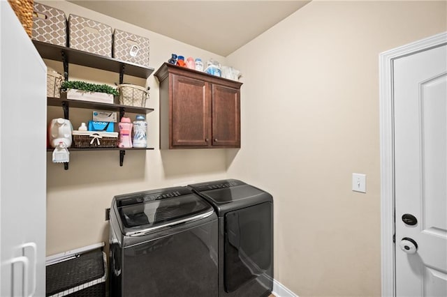 washroom with washer and dryer, cabinet space, and baseboards