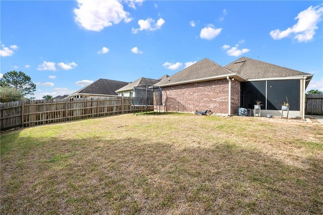 view of yard with a fenced backyard and a trampoline