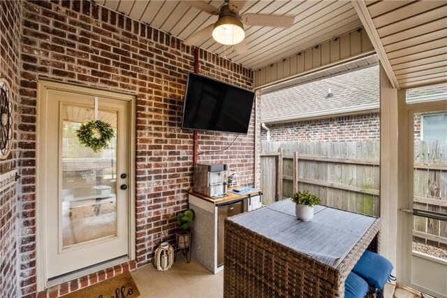 interior space with ceiling fan and fence