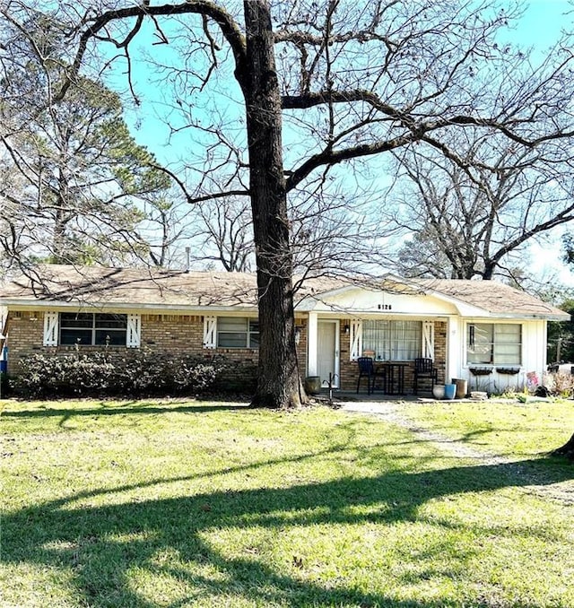 view of front of property with a front lawn and brick siding