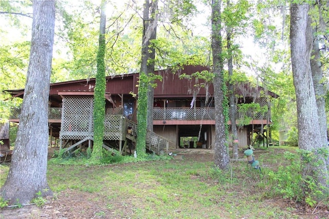back of property featuring a wooden deck and stairs