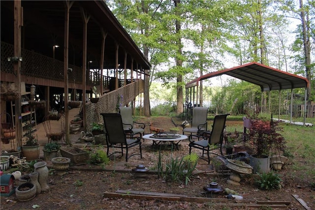 view of yard with stairway, an outdoor fire pit, and a carport