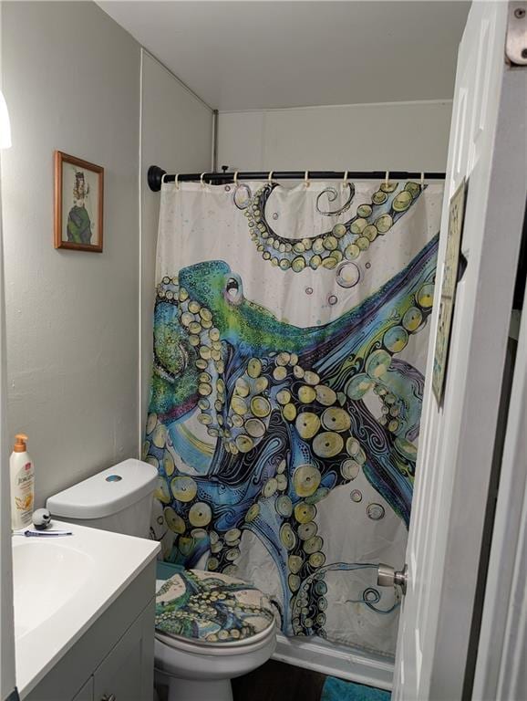 bathroom featuring vanity, curtained shower, and toilet