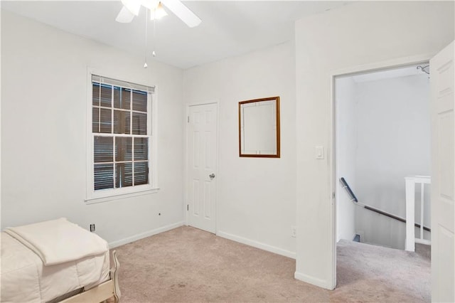 living area with light carpet and ceiling fan