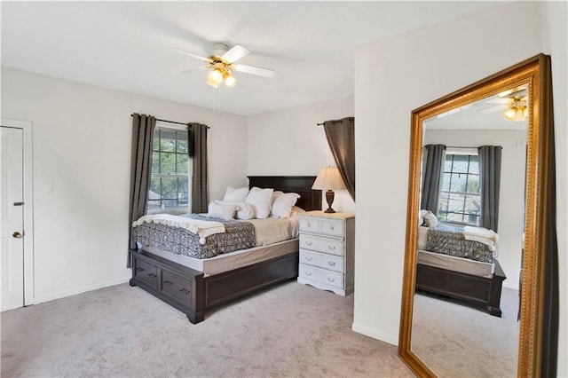 carpeted bedroom featuring ceiling fan and multiple windows