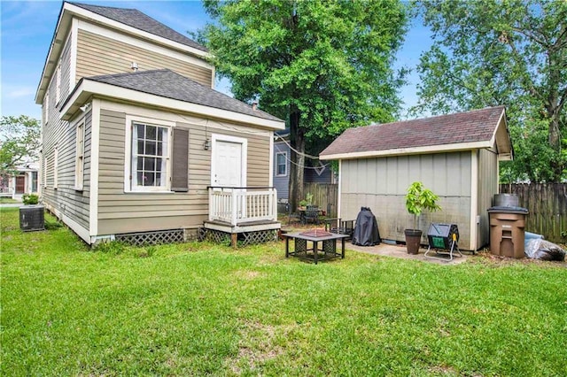 rear view of property with a yard and central AC