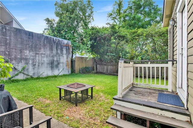 view of yard featuring a wooden deck and an outdoor fire pit