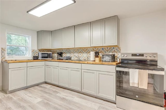 2711 Briley St, Mobile, AL 36606 - kitchen with appliances with stainless steel finishes, backsplash, light wood-style floors, and gray cabinets