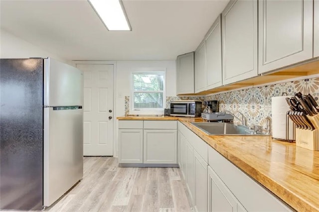 2711 Briley St, Mobile, AL 36606 - kitchen with appliances with stainless steel finishes, light wood finished floors, and tasteful backsplash