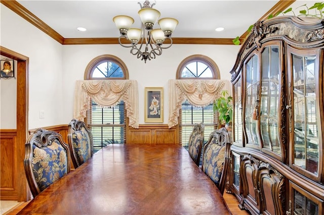 dining area featuring ornamental molding, wood walls, a chandelier, and plenty of natural light