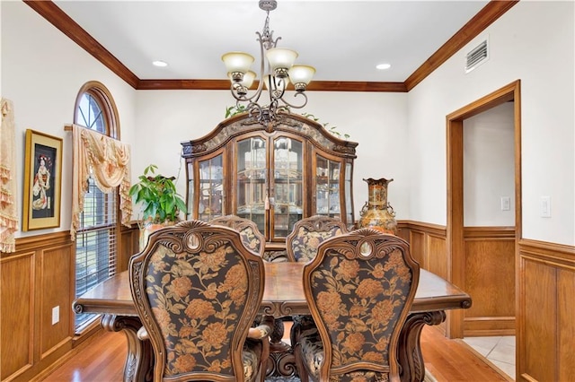 dining space with a chandelier, light tile patterned flooring, and crown molding