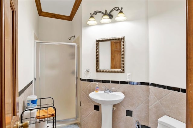 bathroom with tile walls, ornamental molding, toilet, and an enclosed shower