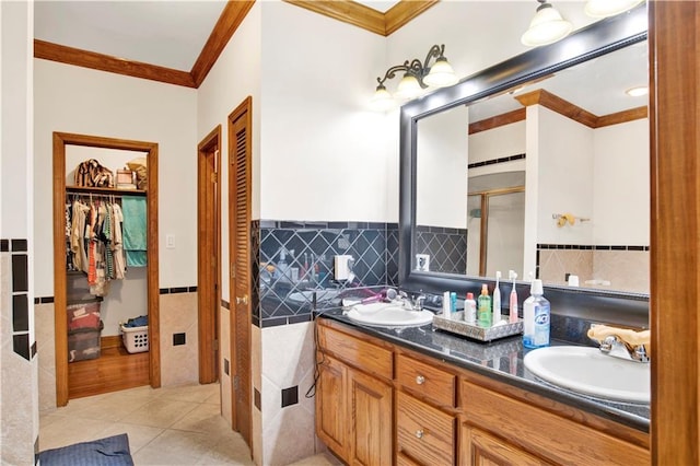 bathroom featuring tile patterned floors, a shower with shower door, vanity, crown molding, and tile walls