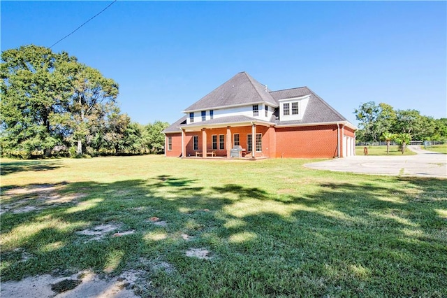 rear view of property with a porch and a lawn