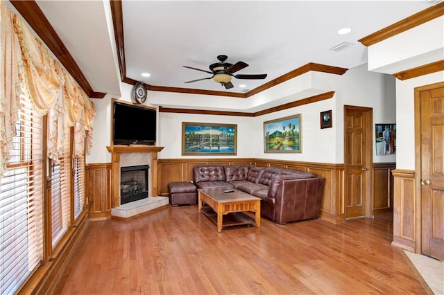 living room featuring ornamental molding, light wood-type flooring, and ceiling fan