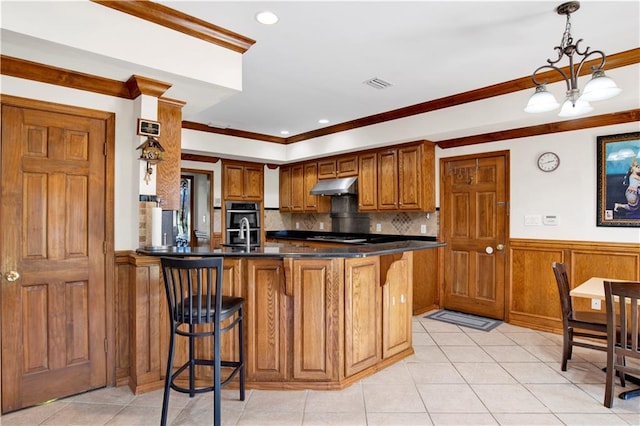 kitchen with a breakfast bar area, a chandelier, kitchen peninsula, and decorative light fixtures