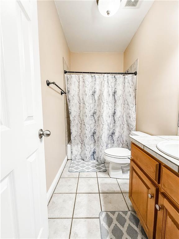 2801 Dog River Rd, Theodore, AL 36582 - bathroom with vanity, toilet, tile patterned flooring, and curtained shower