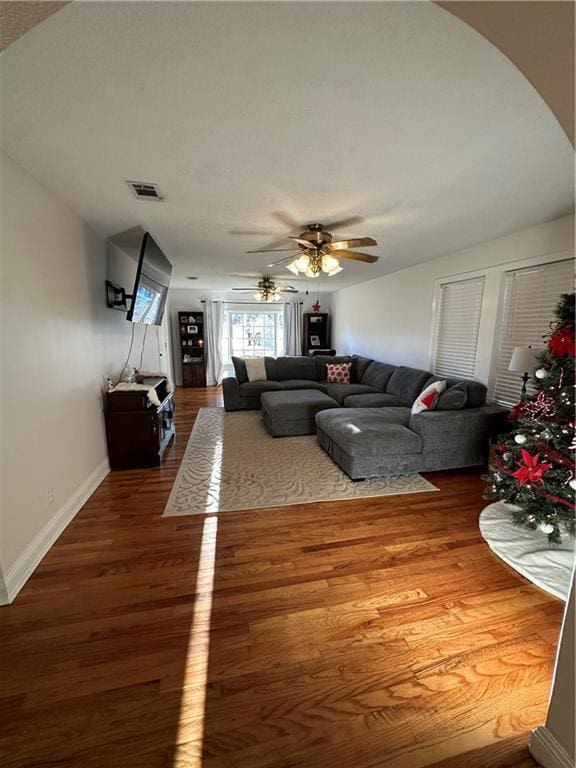 living room featuring ceiling fan and hardwood / wood-style flooring