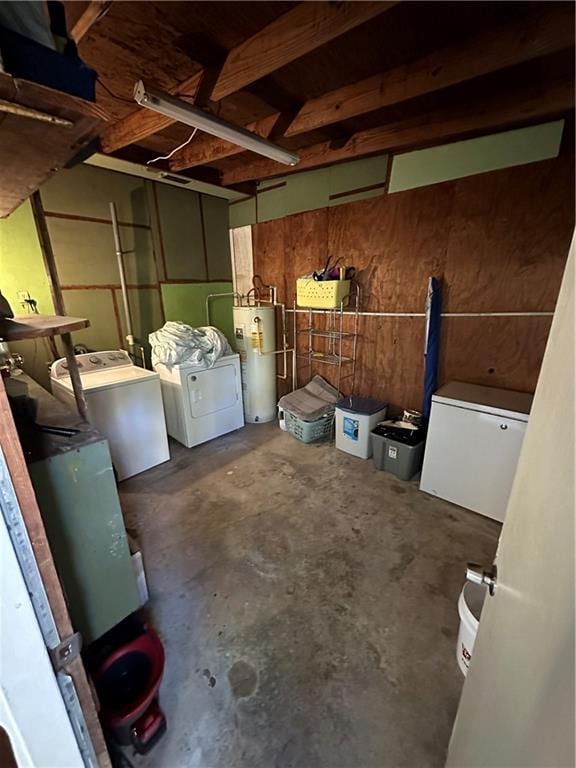 basement with water heater, washer and clothes dryer, and white refrigerator