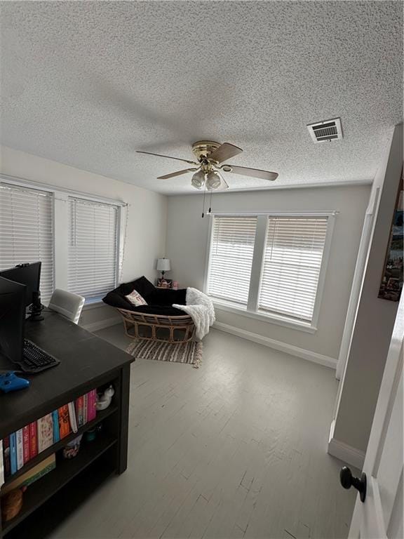 bedroom with ceiling fan, wood-type flooring, and a textured ceiling