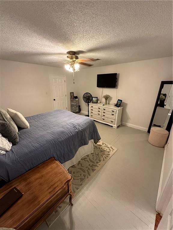 bedroom featuring ceiling fan and a textured ceiling