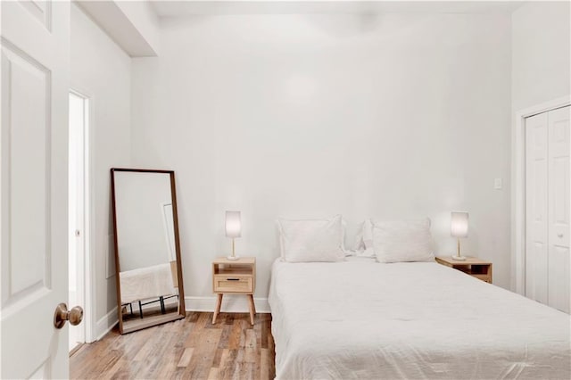 bedroom with light hardwood / wood-style flooring and a closet