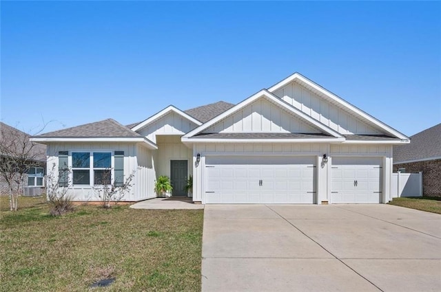 view of front of house with a garage, driveway, a shingled roof, and a front yard