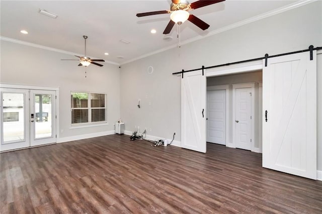 unfurnished living room featuring a barn door, ceiling fan, dark hardwood / wood-style flooring, and ornamental molding