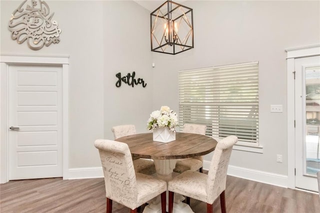 dining space with wood-type flooring and a notable chandelier