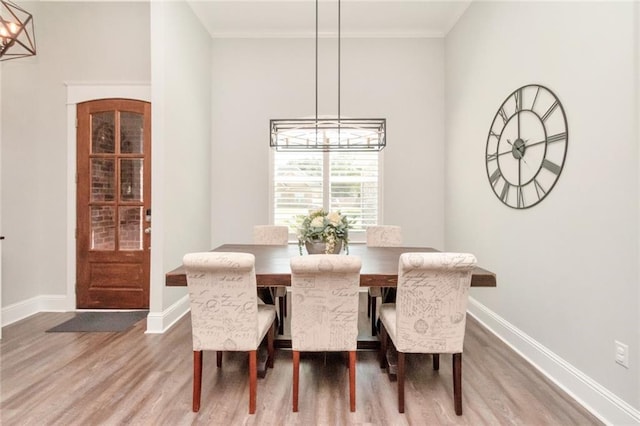 dining room with an inviting chandelier, hardwood / wood-style floors, and ornamental molding