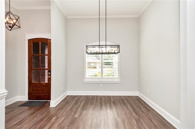 unfurnished dining area with dark hardwood / wood-style floors, a notable chandelier, and ornamental molding