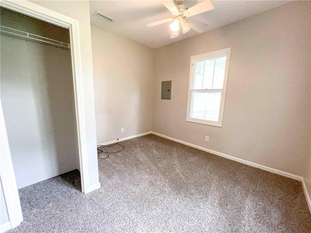 unfurnished bedroom featuring electric panel, baseboards, visible vents, carpet, and a closet