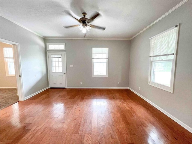 interior space featuring baseboards, wood finished floors, and crown molding