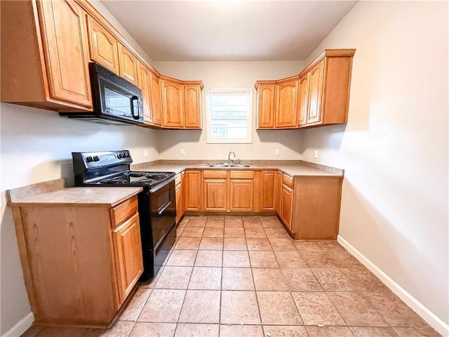 kitchen with light tile patterned floors, baseboards, light countertops, black appliances, and a sink