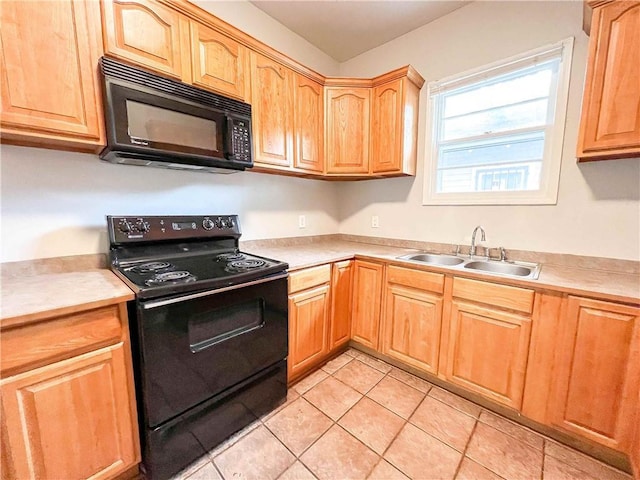 kitchen with light countertops, a sink, and black appliances