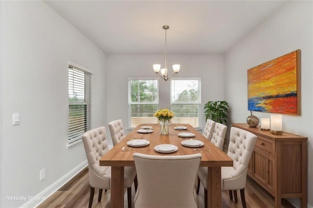 dining area with hardwood / wood-style floors and an inviting chandelier