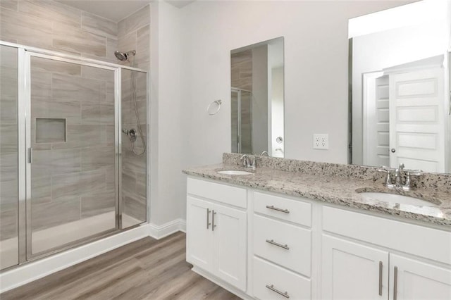 bathroom featuring wood-type flooring, vanity, and a shower with door