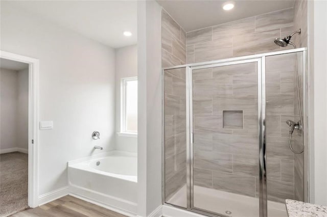 bathroom featuring separate shower and tub and hardwood / wood-style floors