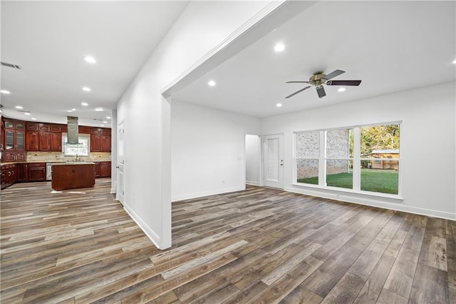 unfurnished living room with dark wood-type flooring, sink, and ceiling fan